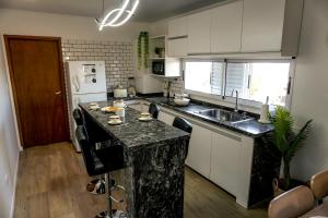 a kitchen with a granite counter top and a sink at Departamento a estrenar a pasos del pulmón de la cuidad in San Nicolás de los Arroyos +40 photos
