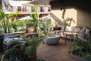 an outdoor patio with couches and tables and plants at Four Hills Hotel in Antalya