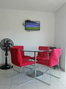 a table with red chairs and a television on a wall at Modern apartment with pool-La Mesa in La Mesa