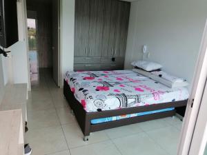 a bedroom with a bed with a floral bedspread at Modern apartment with pool-La Mesa in La Mesa