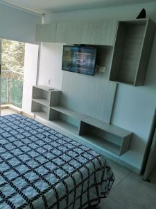 a bedroom with a bed and a flat screen tv at Modern apartment with pool-La Mesa in La Mesa