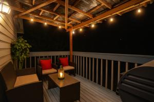 a balcony with two chairs and a table and lights at Remodeled, Spacious, Modern Retreat 5 BR, 3BA, 2KIT in Shoreline