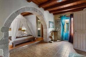 a bedroom with a bed and an arched doorway at Villa Epavlis in Plaka