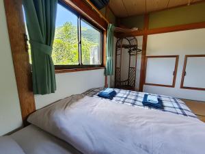 a bed in a room with a window at Ikada in Amami