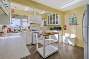 a kitchen with white cabinets and a table in it at Coastal Coziness in Cayucos +28 photos