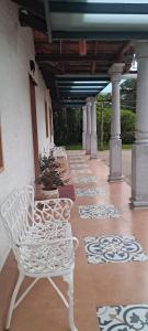 a row of white benches sitting on a porch at Krushikoota Homestay in Sringeri