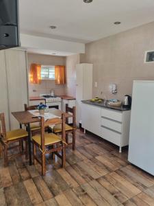 a kitchen with a table and chairs and a refrigerator at El Encuentro in Sierra de los Padres