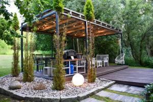 a wooden gazebo with a table and chairs at Cobalt Apartments in Mikołajki