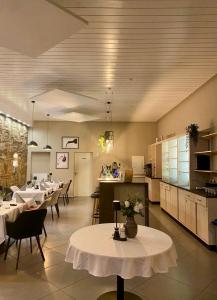 a dining room with tables and chairs and a kitchen at Pension DaVinci in Schwetzingen