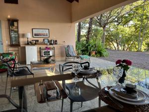 a living room with a glass table and chairs at Loft em chácara Espírito Santo in Espirito Santo Do Pinhal