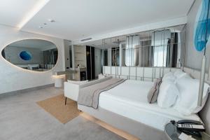 a bedroom with a large white bed and a large mirror at Four Hills Hotel in Antalya