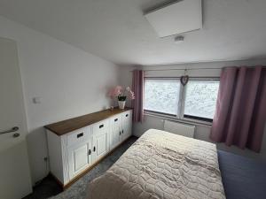 a bedroom with a bed and a dresser and a window at Annas Ruheoase in Meißendorf