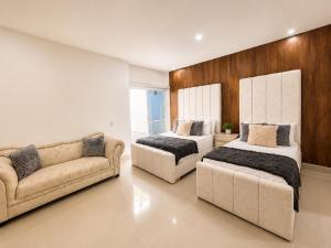 a living room with two beds and a couch at La Toscana del Poblado in Medellín