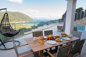 a wooden table with fruit on top of a balcony at Aifantis Villa 1 in Póndi