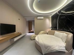 a living room with a couch and a flat screen tv at Mia Hotel in Ga Trảng Bôm