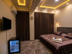 a hotel room with a bed and a television at Hotel Buston in Chkalovsk