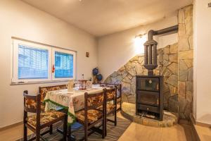 a dining room with a table and a wood stove at Villa Stefan Kozuf in Konsko