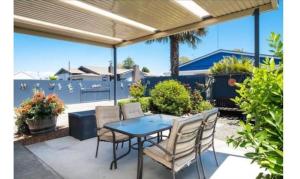 a patio with a table and chairs and a fence at The Napier Stay in Napier