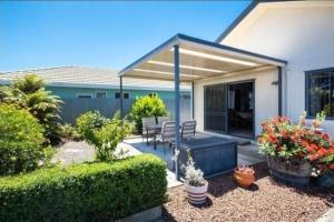 a patio with a table and chairs and plants at The Napier Stay in Napier