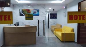 a hotel lobby with a yellow chair and a desk at Georgetown New Wave Hotel in George Town