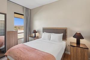 a bedroom with a large bed and a balcony at Sentral Old Town in Scottsdale +23 photos