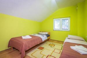 a green room with two beds and a window at Villa Stefan Kozuf in Konsko