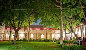 a building with trees in front of a yard at Mystic Paradise in Jaipur