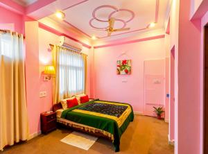 a bedroom with a bed in a room with pink walls at Mystic Paradise in Jaipur