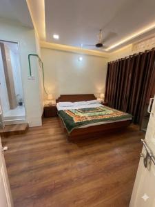 a bedroom with a bed and a wooden floor at Hotel shree in Indore
