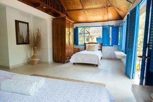 a bedroom with a bed and blue shuttered windows at Bayside Island in Cartagena de Indias