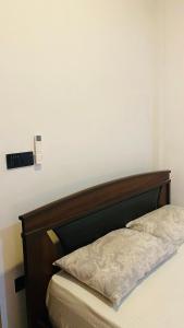 a bed with a wooden headboard in a room at Calm bay in Minneriya