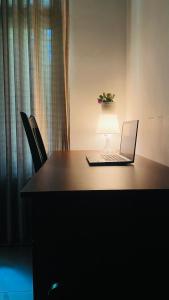 a laptop computer sitting on a table with a lamp at Calm bay in Minneriya +1 photo