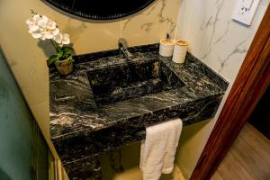 a bathroom sink with a black marble counter top at Departamento a estrenar a pasos del pulmón de la cuidad in San Nicolás de los Arroyos