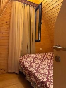 a bedroom with a bed next to a window at Tlughi cottage in Obcha
