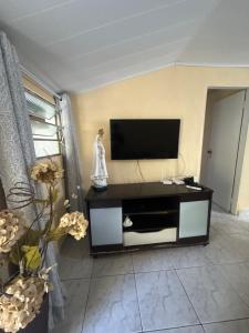 a living room with a flat screen tv at Casa baixinha in Ubajara