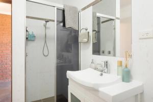 a white bathroom with a sink and a shower at Viewpoint in Tathra +38 photos
