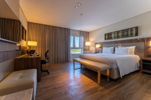 a hotel room with a large bed and a desk at Deville Prime Campo Grande in Campo Grande +35 photos