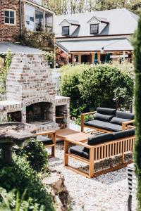 a patio with two benches and a fireplace at The Berrima Vault House in Berrima