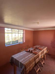 a dining room with a table and chairs and a window at Kusikuy Wasy Lodge in Puno