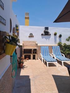 two blue and white chairs on a patio with a fireplace at Casa La Tapita in Marbella