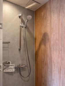 a shower in a bathroom with a shower head at Yamamori House in Hakuba +33 photos