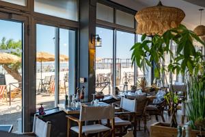 a restaurant with tables and chairs and a view of the ocean at Acadie Saint Victor - Hôtel restaurant -Face mer- Châtelaillon plage in Châtelaillon-Plage