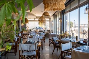 a restaurant with tables and chairs and windows at Acadie Saint Victor - Hôtel restaurant -Face mer- Châtelaillon plage in Châtelaillon-Plage
