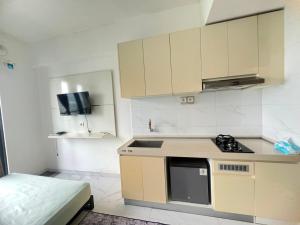 a small kitchen with a sink and a stove at Sky House BSD By Micky Studio in Cilenggang