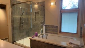 a bathroom with a shower and a tub and a sink at Test Villa in Victoria