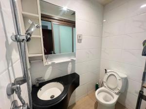 a bathroom with a toilet and a mirror at Sky House BSD By Micky Studio in Cilenggang +8 photos