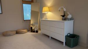 a bedroom with a dresser with a lamp and a mirror at Test Villa in Victoria