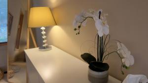 a table with a lamp and a vase of flowers on it at Test Villa in Victoria