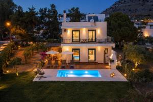 a house with a swimming pool in front of it at Villa Calliope Lardos in Lartos