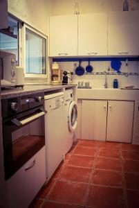 a kitchen with a stove and a washer and sink at Au coeur de Leucate in Leucate